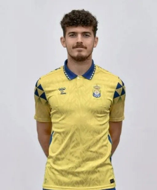 Portrait of a man in a yellow soccer jersey.