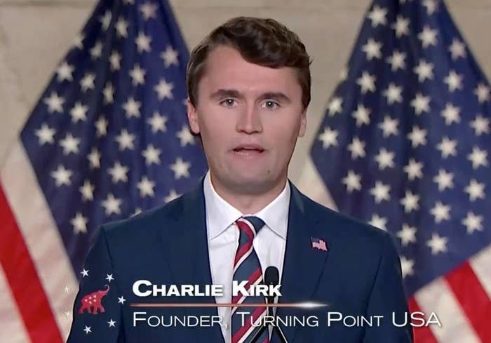 A person in a suit and tie speaks at a podium, with multiple U.S. flags in the background. Text on screen: "Charlie Kirk, Founder Turning Point USA."
