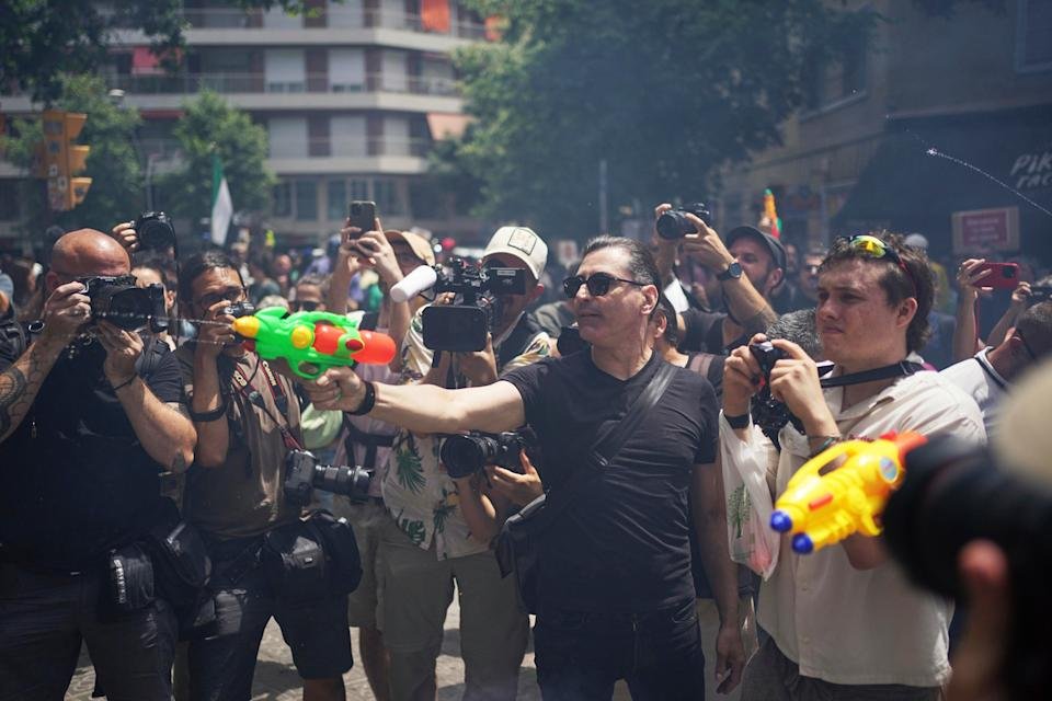People shoot in the direction of tourists with water guns during a protest against overtourism in Barcelona, Spain, Sunday, June 15, 2025. (AP Photo/Pau Venteo)