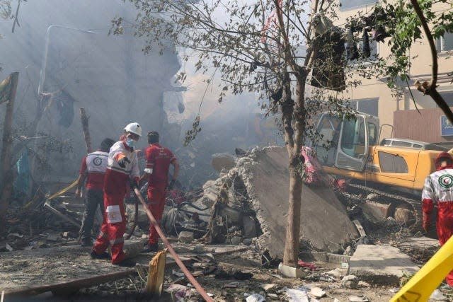 Rescuers work at the scene of an explosion in Tehran