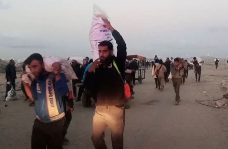 Palestinians carry aid supplies which they received from the U.S.-backed Gaza Humanitarian Foundation, in Rafah, in the southern Gaza Strip, June 3, 2025 (photo credit: REUTERS TV)