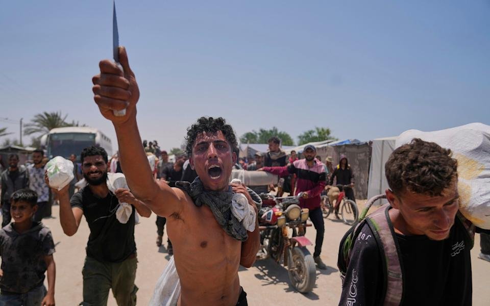 A Palestinian shouts in Arabic 'we get food with the taste of death and blood'