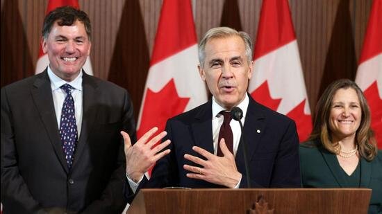 Canada's Prime Minister Mark Carney (C) speaks during a news conference, alongside President of the King’s Privy Council for Canada Dominic LeBlanc (L) and Minister of Transport and Internal Trade Chrystia Freeland (R), during a news conference on Parliament Hill, in Ottawa, on Friday. (AFP)