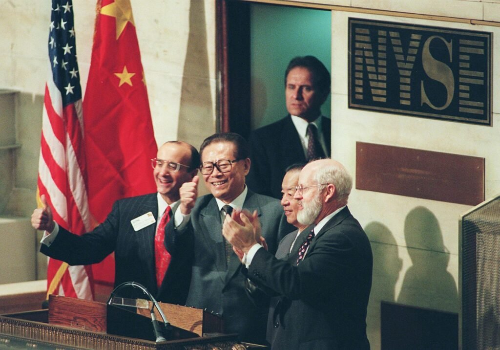 NEW YORK, UNITED STATES: Chinese President Jiang Zemin (C) gives a thumbs-up along with New York Stock Exchange Chairman and CEO Richard Grasso (L) after Jiang rang the opening bell 31 October to open trading on the New York Stock Exchange. (Photo credit should read TIMOTHY A. CLARY/AFP via Getty Images)