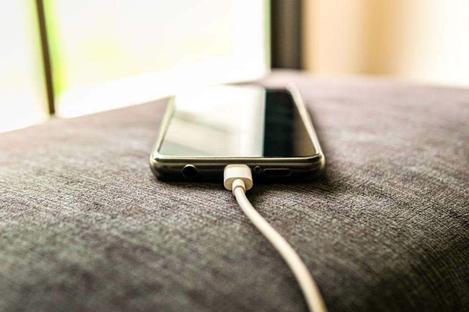 a smartphone charging on a pillow