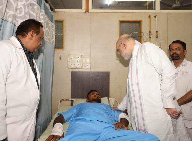 Indian Home Affairs Minister Amit Shah meets British plane crash survivor Viswashkumar Ramesh, who is lying in a hospital bed.