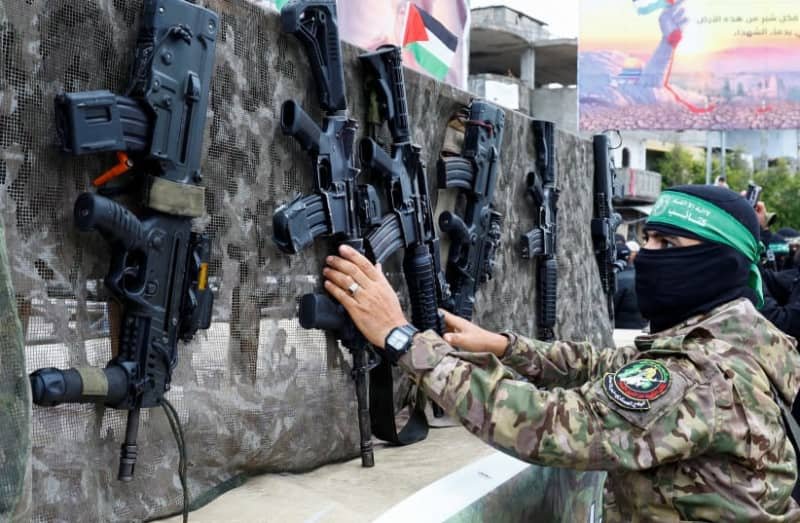 A Palestinian Hamas terrorist displays guns on the day of the handover of hostages, in Rafah in the southern Gaza Strip, February 22, 2025. (photo credit: REUTERS/Hatem Khaled)