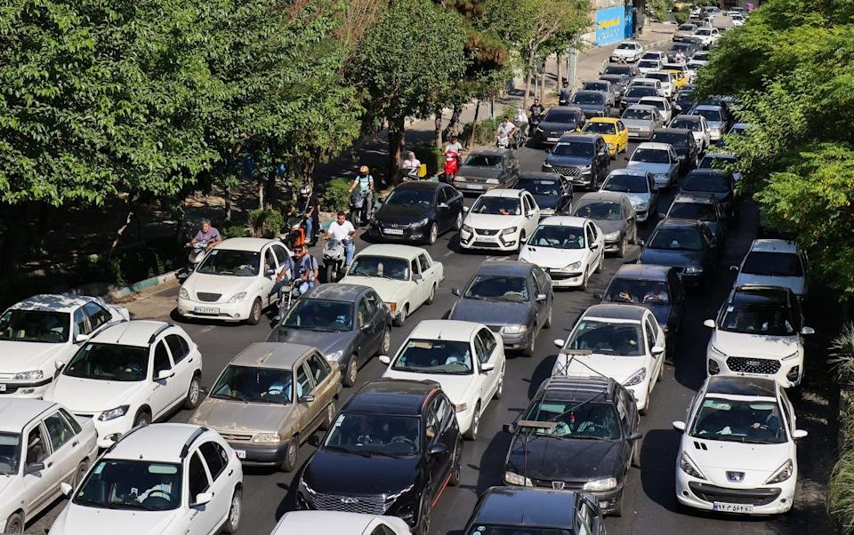 Vehicles wait in traffic as people get out of Tehran through an artery in the city's west on June 15, 2025