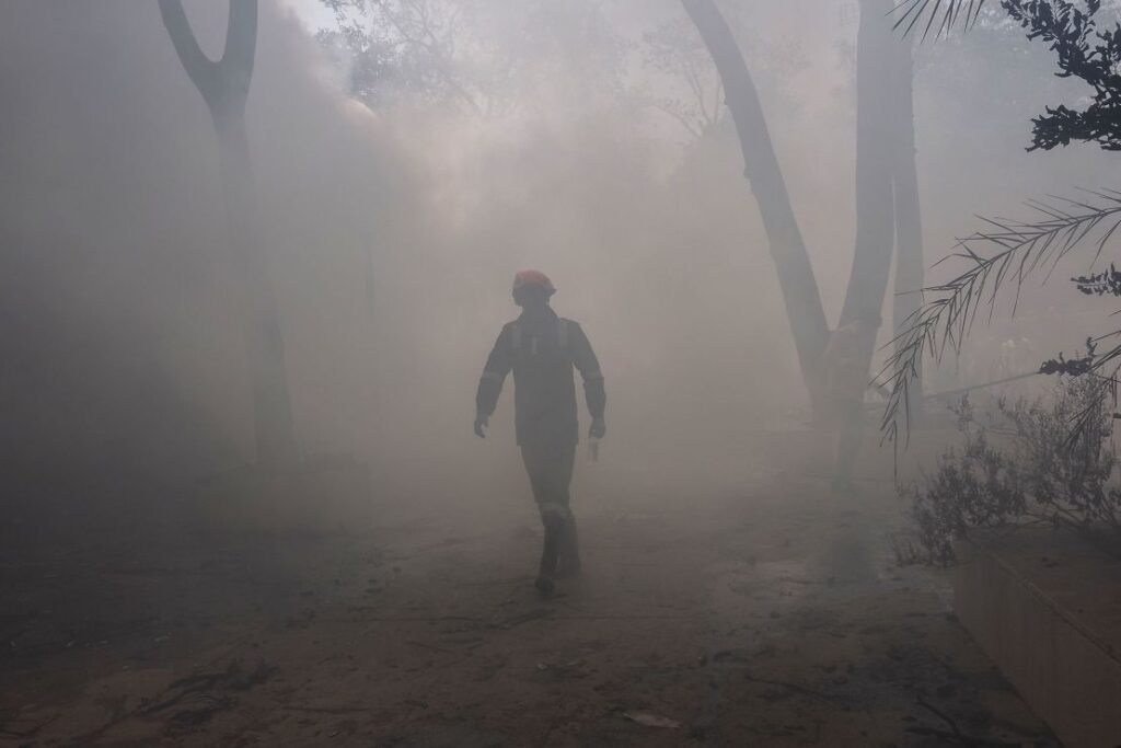 A firefighter works at the site where Air India flight 171 crashed in a residential area near the airport in Ahmedabad on June 12, 2025.