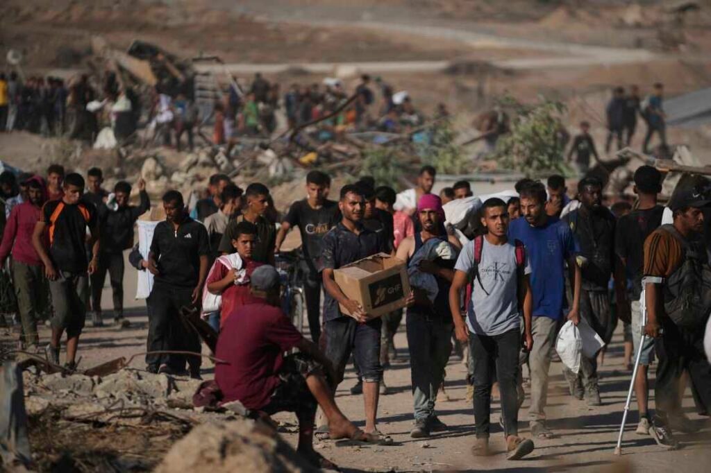 Palestinians carry food packages near a distribution site operated by the U.S.-backed Gaza Humanitarian Foundation in Khan Younis, southern Gaza Strip, Thursday. (AP Photo/Abdel Kareem Hana)
