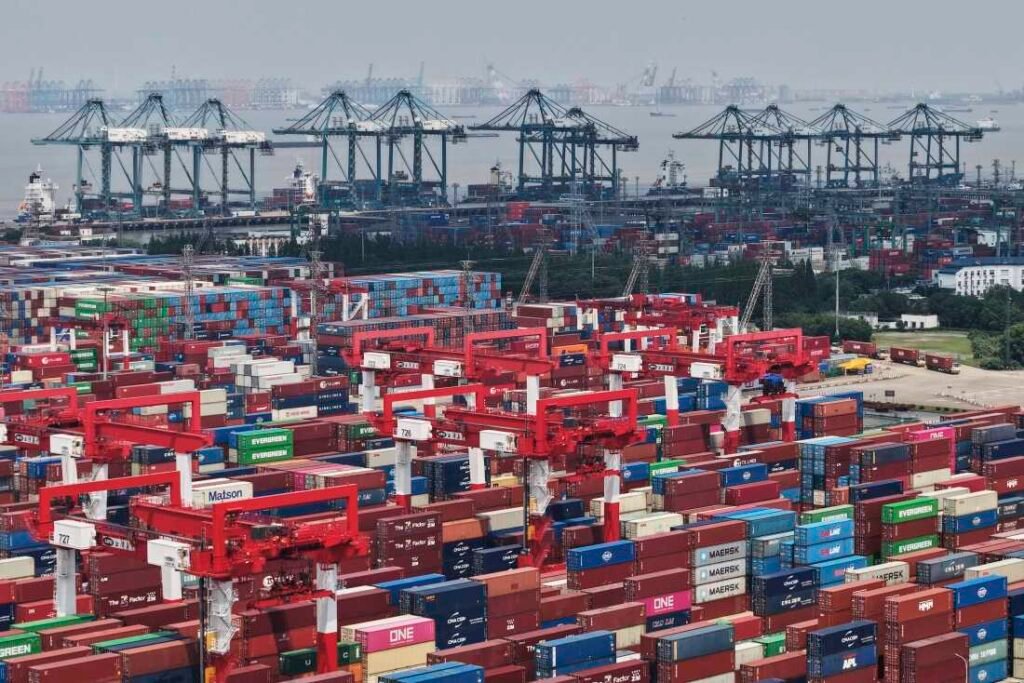 Trucks loaded with containers move through a port in Shanghai, China Monday, June 9, 2025.