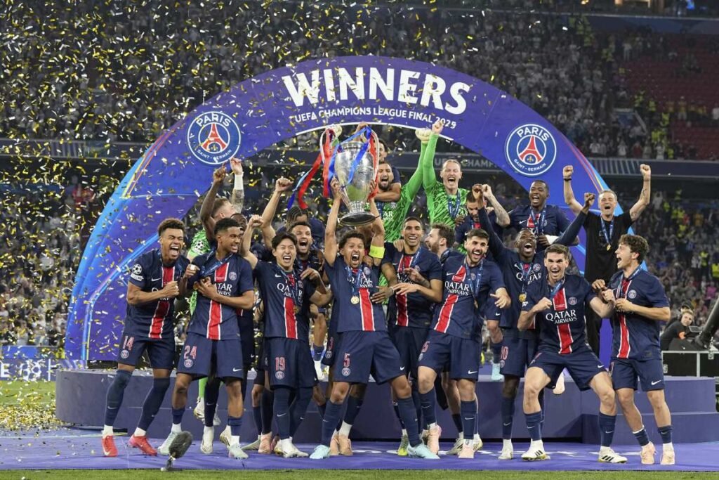 PSG's Marquinhos holds up the trophy as he celebrates with his teammates.