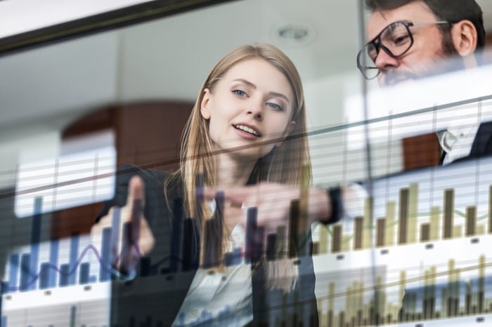 Two people looking at a graph.