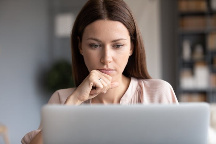 Person staring intently at laptop.
