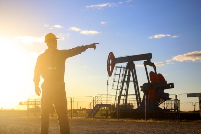 A worker beside an oil pump.