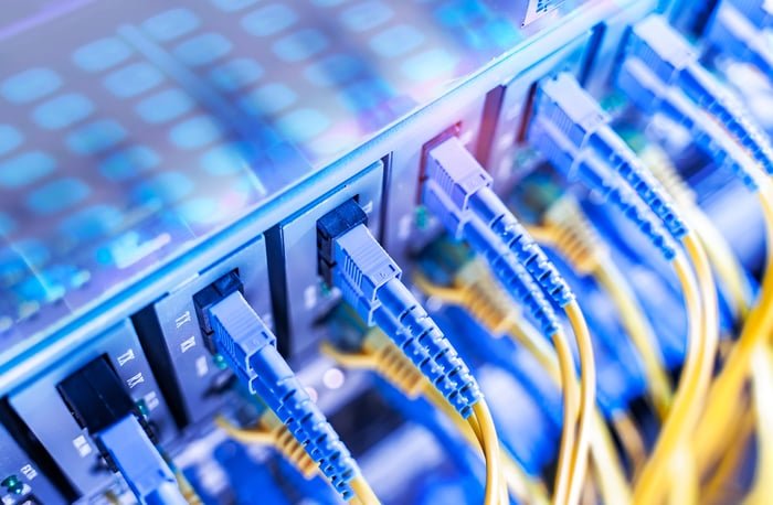 Cables are plugged into computer networking hardware.