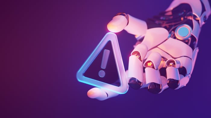 A robotic hand holding a digital warning sign.