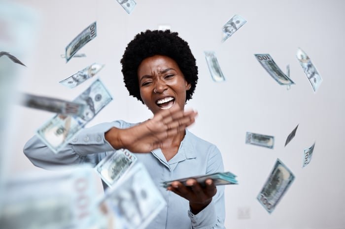 A person throwing dollars.
