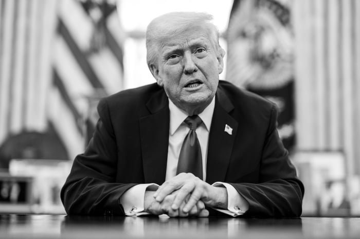 President Donald Trump discussing auto tariffs while seated at a desk in the Oval Office.