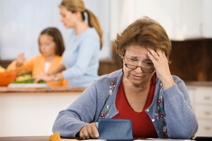 A worried person holding a checkbook.