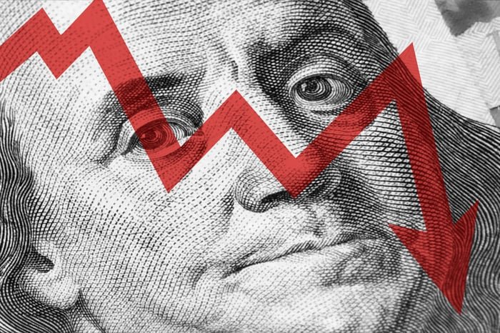 An arrow moving down over a hundred-dollar bill.