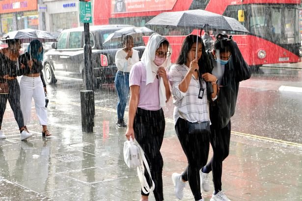 London, UK. August 7th 2021.  People walking down Oxford Street in a heavy summer shower.