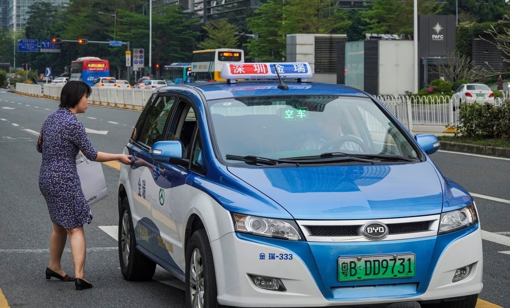 A passenger boards an electric taxi in Shenzhen, Guangdong province on March 19, 2019. Photo: Roy Issa