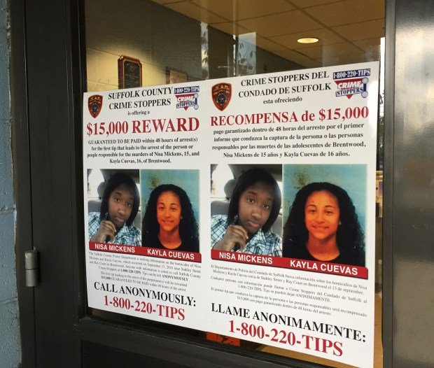 In this Oct. 24, 2016 file photo, a poster displayed at a Suffolk County police precinct in Bay Shore, N.Y., offers a $15,000 reward for information leading to the arrest of the person(s) responsible for the slayings of Nisa Mickens and her lifelong friend Kayla Cuevas. (AP Photo/Michael Balsamo, File)
