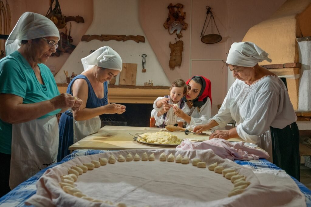 A group of people around a table prepping dough.