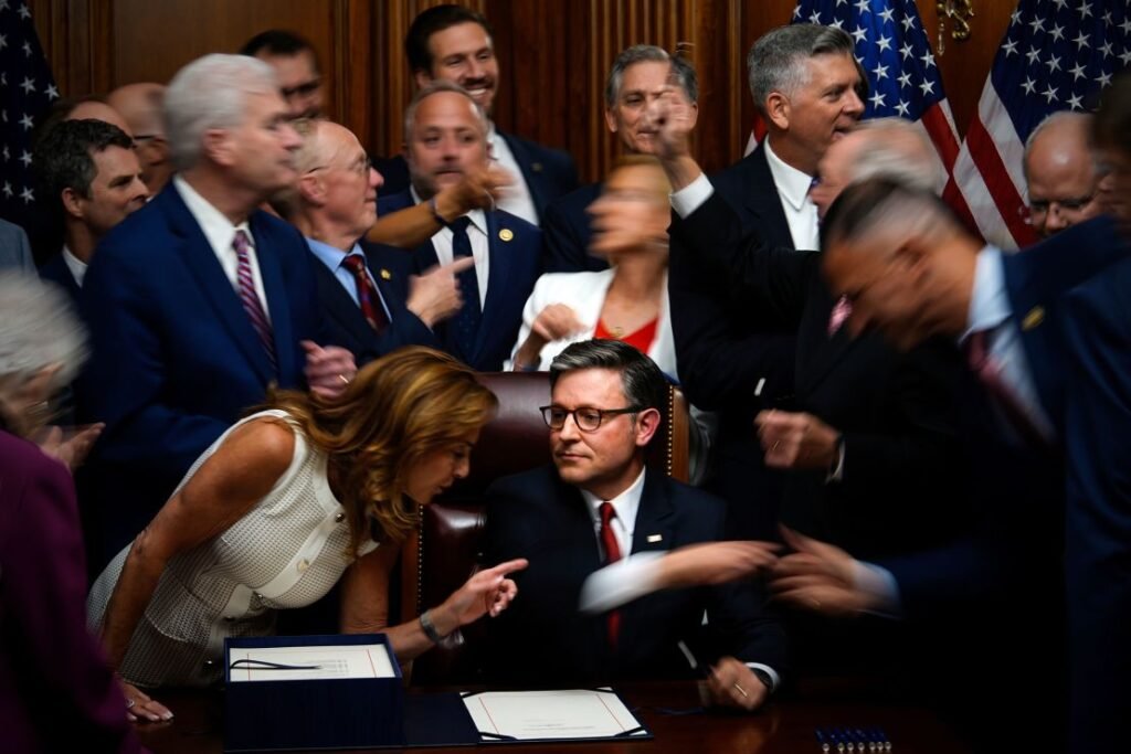 Republican members of Congress reach to shake hands with Speaker of the House Mike Johnson, after Johnson signed the bill.