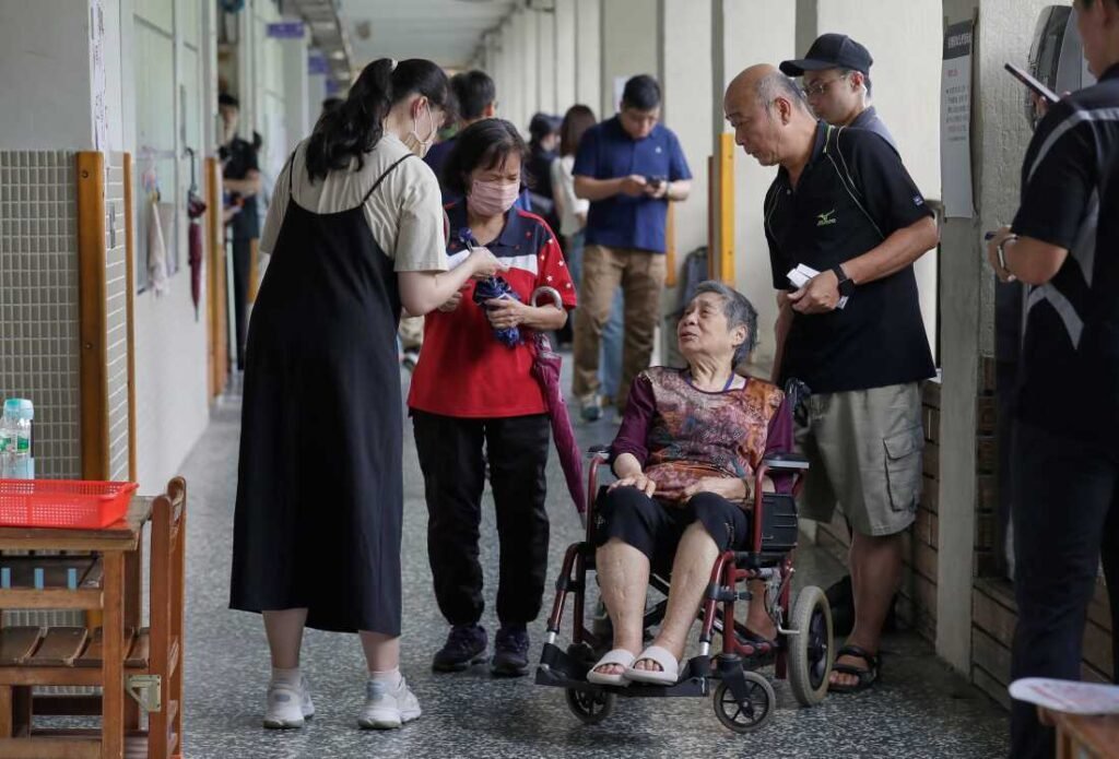 Taiwanese people go to vote at a polling station in Taipei, Taiwan, on Saturday to determine whether to oust about one-fifth of their lawmakers, all from the opposition Nationalist Party, in elections.