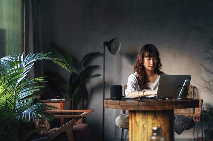 Person sitting at a desk working on a laptop.