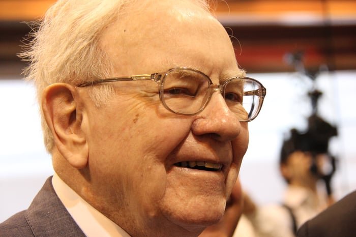 Warren Buffett smiling at an event.