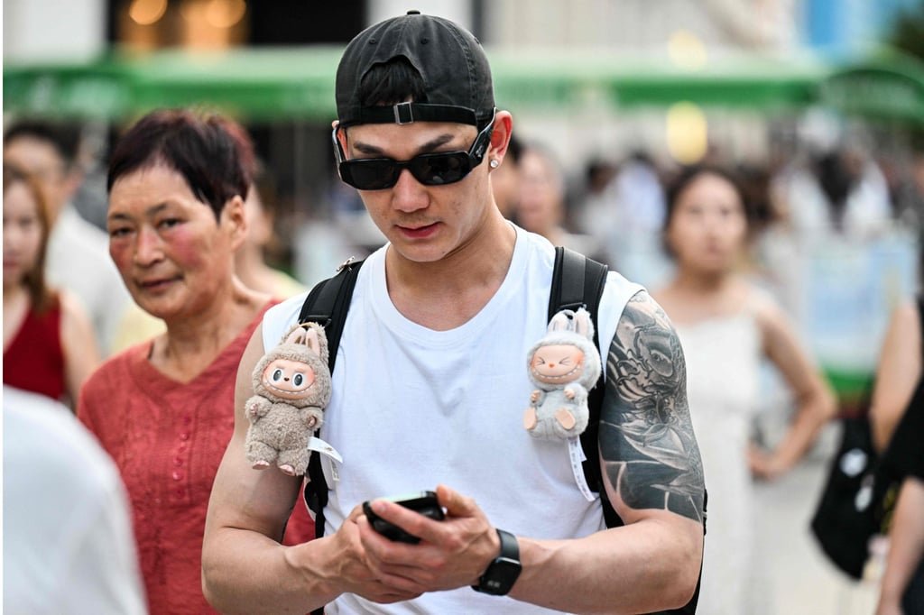 A man walks with two Labubu plush toys hanging from his backpack at The Bund in Shanghai on July 4, 2025. Photo: AFP