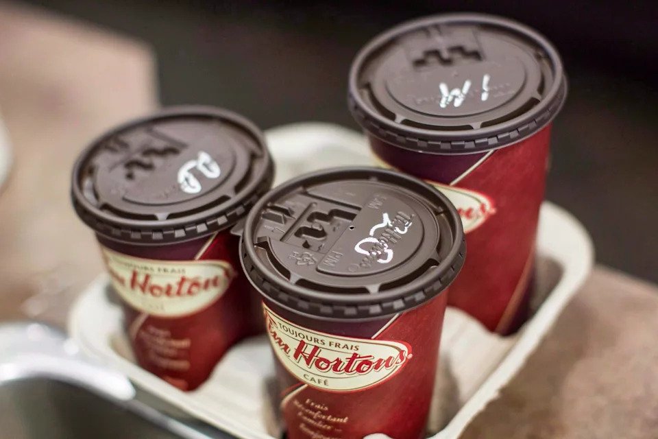 Cups of coffee sit on a counter in a Tim Hortons outlet in Oakville, Ont. on Monday Sept. 16, 2013. Ads for pipeline giant Enbridge will no longer be seen by Canadians waiting in line for double-doubles and Timbits. The spots had been airing for close to three weeks on screens at more than 1,500 Tim Hortons locations between British Columbia and Ontario. THE CANADIAN PRESS/Chris Young