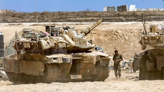 Israeli army main battle tanks are positioned near the border with the Gaza Strip in southern Israel on August 27, 2025. Israeli military pressed operations around Gaza City on August 27, as President Donald Trump prepared to host a White House meeting on post-war plans for the shattered Palestinian territory. (Photo by Jack GUEZ / AFP)(AFP)