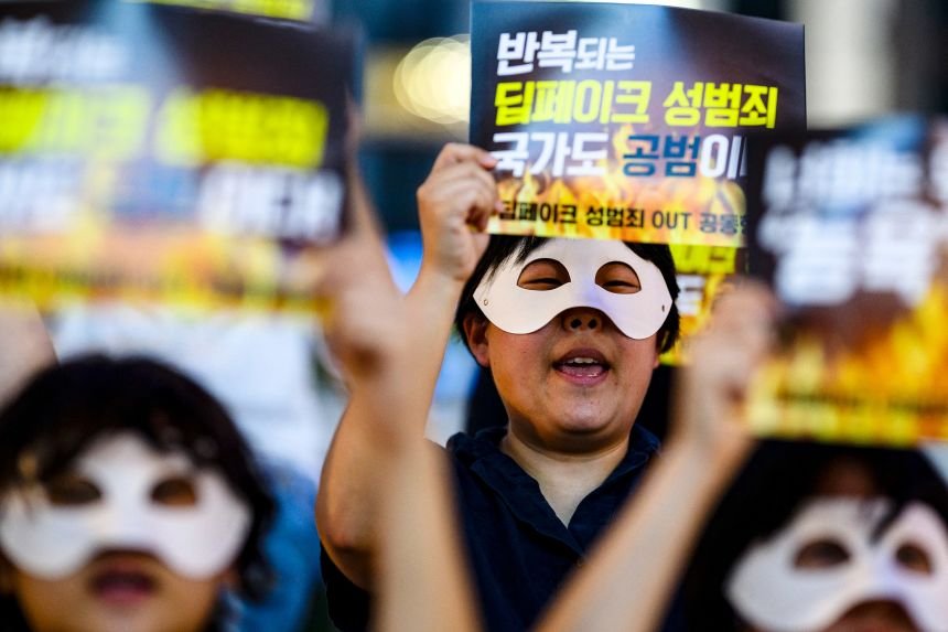 South Korean activists wearing eye masks hold posters reading 'Repeated deepfake sex crimes, the state is an accomplice too' during a protest against deepfake porn in Seoul on August 30, 2024.