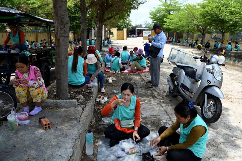 Garment workers have lunch outside their factory in Phnom Penh on April 3, 2025.