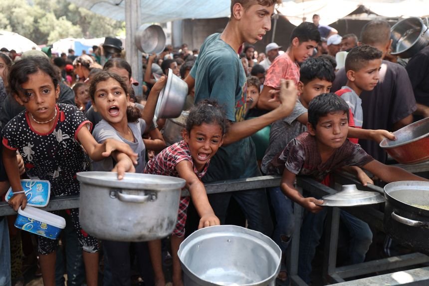 Palestinians gather to receive cooked meals from a food distribution center in the Nuseirat refugee camp in the central Gaza Strip on August 18, 2025.(Photo by Eyad BABA / AFP) (Photo by EYAD BABA/AFP via Getty Images)