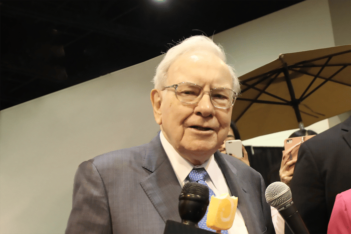 Warren Buffett eating ice cream while being interviewed by the media.