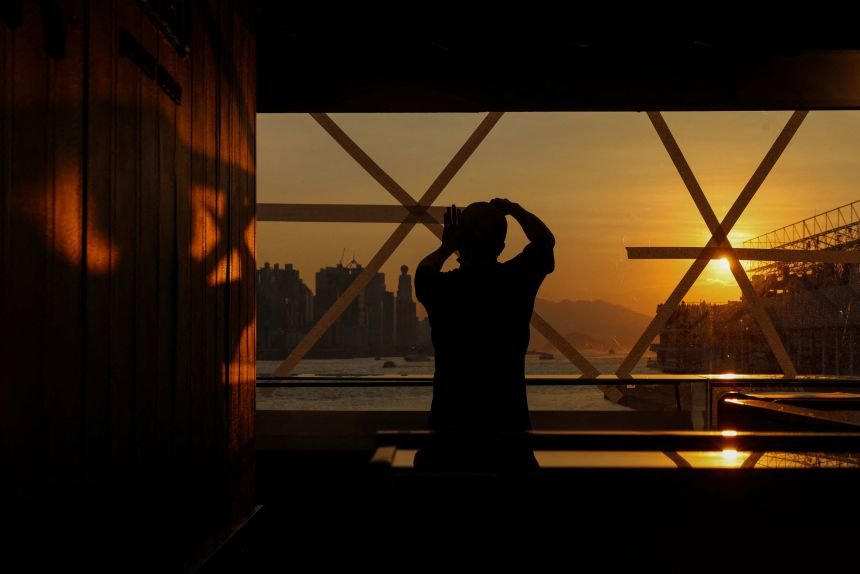 A shop worker tapes a glass window in preparation for Typhoon Ragasa at a store in Hong Kong, on September 22, 2025.
