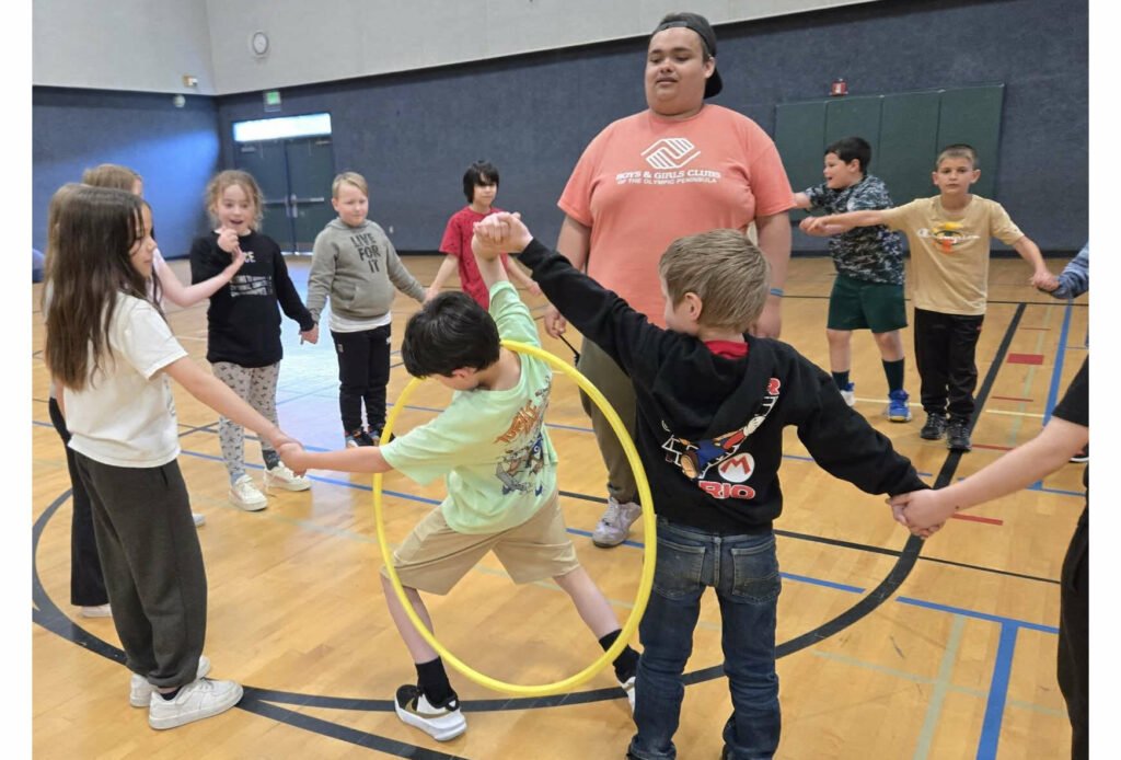 Photo courtesy of the Boys & Girls Clubs of the Olympic Peninsula/ Youth Development staffer Aymon Anderson leads a group of elementary school children in a hula hoop challenge as part of the Sequim Boys & Girls Clubs Project L.A.N.E.