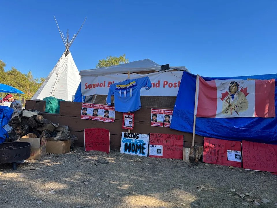 Volunteers chop wood and tend to a sacred fire, around tents in Edmonton’s Dawson Park, at a command post to collect donations and coordinate people looking for Samuel Bird.