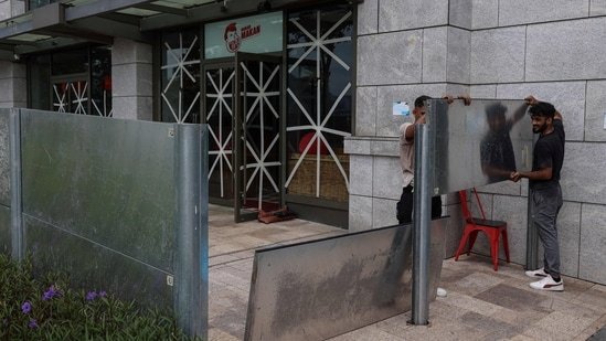Workers install waterproof steel plates to protect against flooding from Super Typhoon Ragasa, in Hong Kong, China, September 23, 2025.(REUTERS)