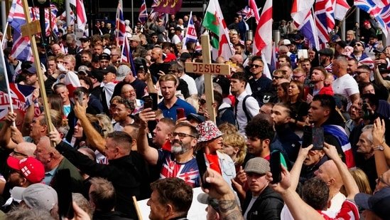 Supporters of British far-right activist Tommy Robinson, whose real name is Stephen Yaxley-Lennon, walk with Union flags and St George's cross and Welsh flags and Christian crosses through central London during a 'Free speech' march, on September 13, 2025. (AFP)