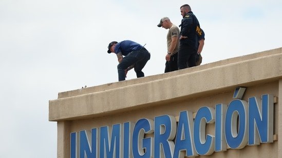 Law enforcement agents look around the roof of a building near the scene of a shooting at a U.S. Immigration and Customs Enforcement office in Dallas on Wednesday, Sept. 24, 2025.(AP)