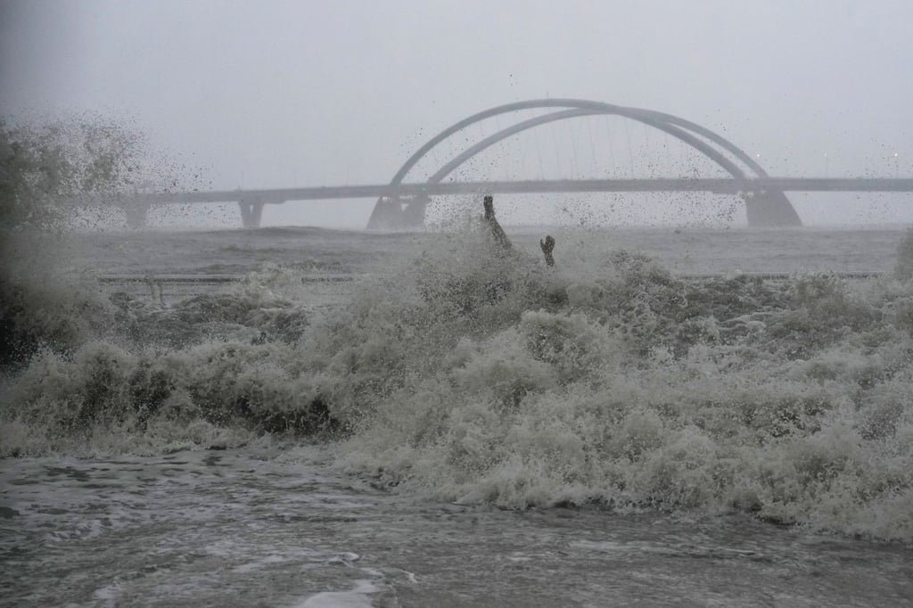 A wave sweeps the man on the bench off his feet during Ragasa. Photo: Elson Li