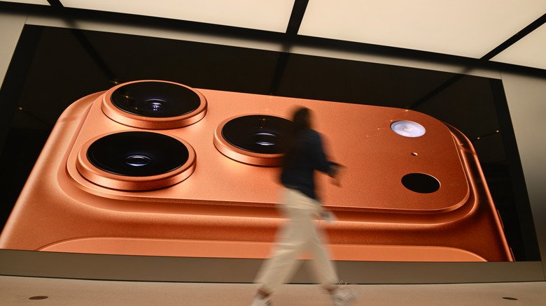A person walking by an iPhone 17 Pro billboard.