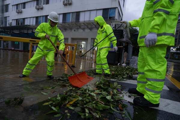 Workers clear debris clogging an entry way in the aftermath of Super Typhoon Ragasa in Shenzhen in southern China's Guangdong province on Wednesday, Sept. 24, 2025. (AP Photo/Ng Han Guan)