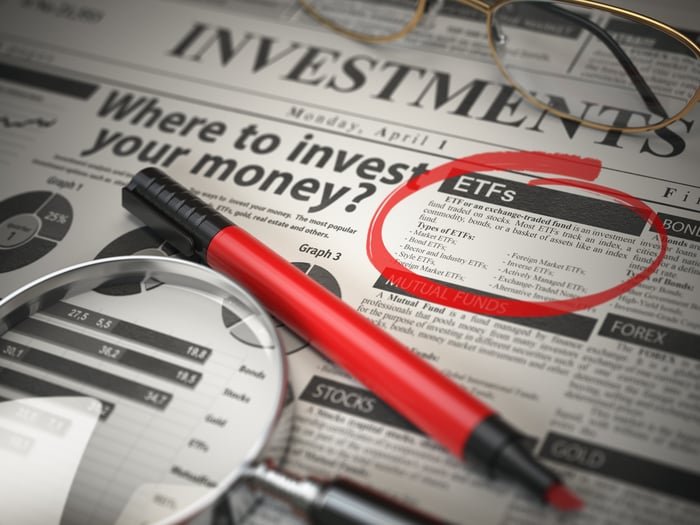 A red pen and a magnifying glass on top of a business newspaper.